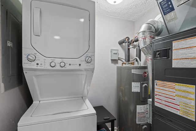 washroom featuring water heater, heating unit, electric panel, a textured ceiling, and stacked washer and clothes dryer