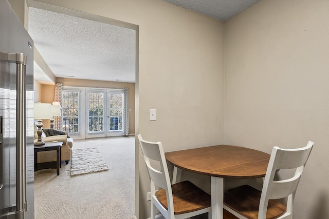 dining space with carpet flooring and a textured ceiling