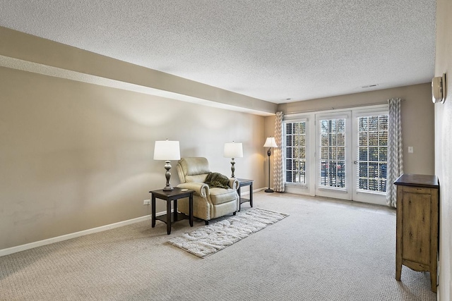 living area featuring light carpet and a textured ceiling