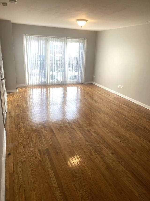 unfurnished room featuring plenty of natural light and wood-type flooring