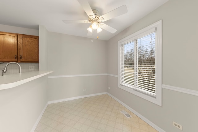 unfurnished dining area with sink and ceiling fan