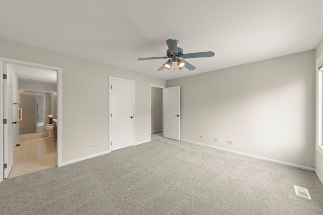 unfurnished bedroom with ceiling fan, light carpet, and ensuite bath