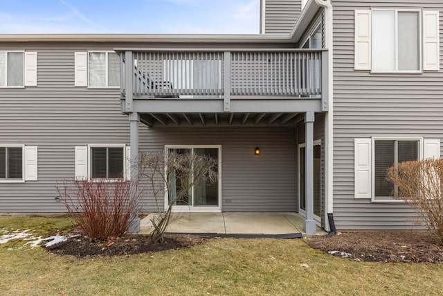 back of property featuring a balcony, a yard, and a patio