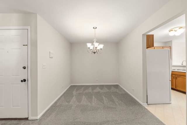 unfurnished dining area featuring an inviting chandelier, sink, and light colored carpet