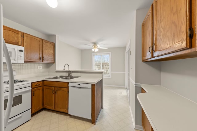 kitchen with sink, white appliances, ceiling fan, decorative backsplash, and kitchen peninsula