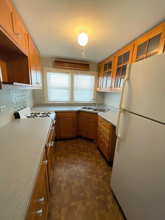 kitchen with sink, white refrigerator, and dark parquet floors