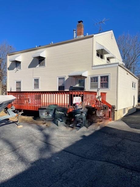 back of property featuring a wooden deck