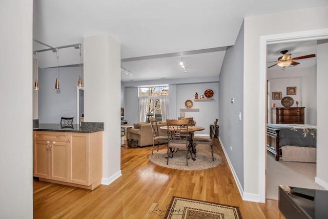 dining room featuring ceiling fan, rail lighting, and light wood-type flooring