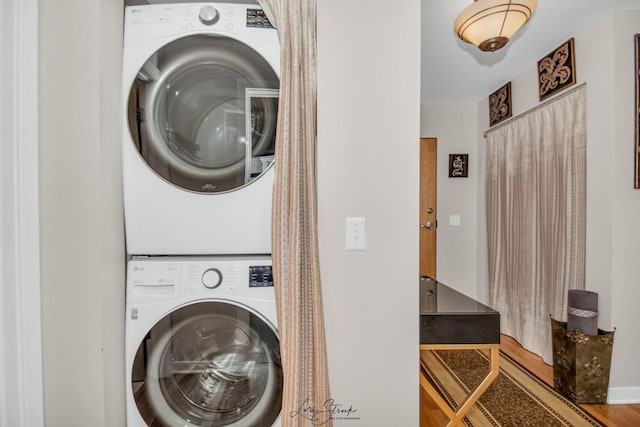 clothes washing area with stacked washer / dryer