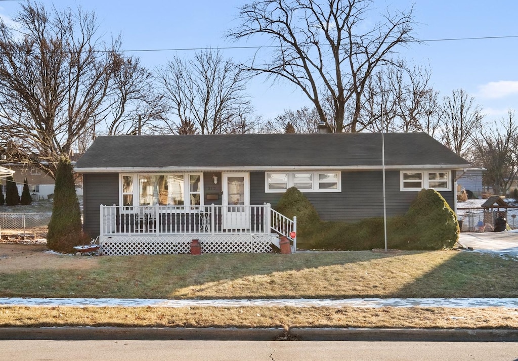 ranch-style house with a front yard and covered porch