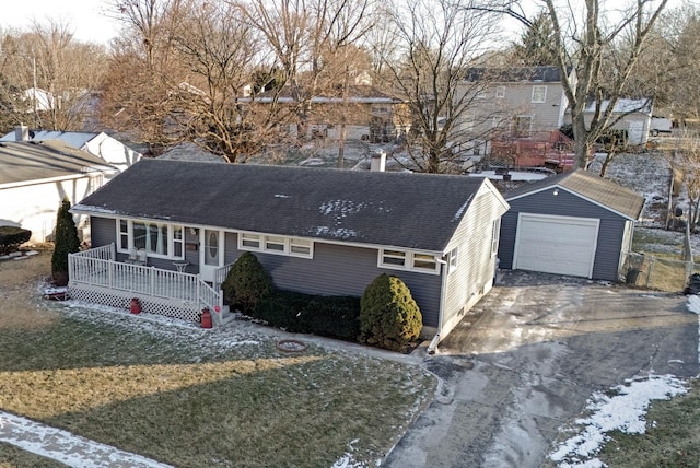 view of front of property with a garage, a front lawn, a porch, and an outbuilding