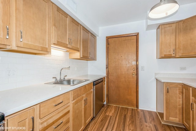 kitchen featuring dark wood-type flooring, sink, stainless steel dishwasher, and tasteful backsplash