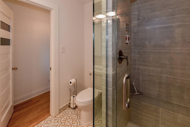 bathroom with hardwood / wood-style flooring, toilet, and walk in shower