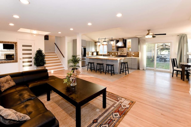 living room featuring ceiling fan and light hardwood / wood-style flooring