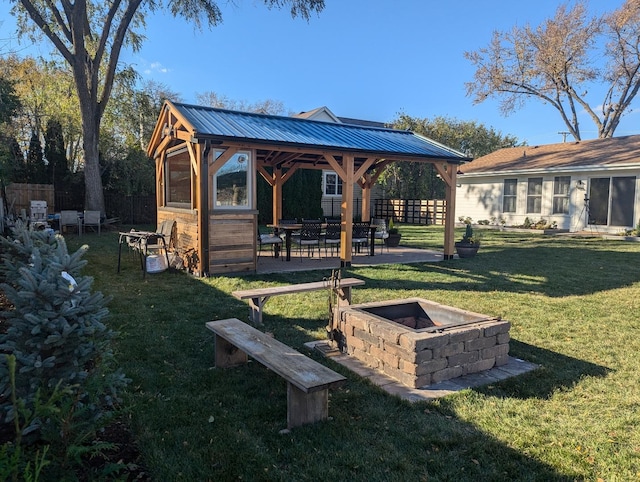 rear view of house featuring a gazebo, an outdoor fire pit, and a lawn