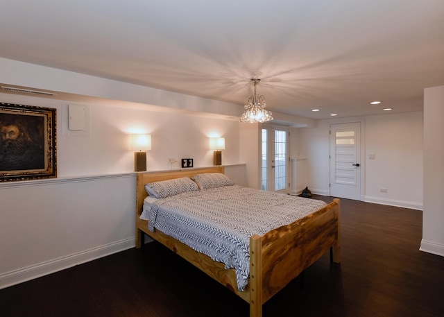 bedroom featuring dark wood-type flooring and an inviting chandelier