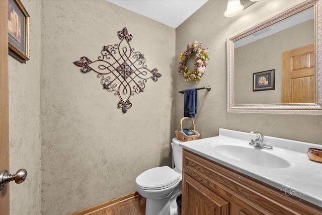 bathroom featuring hardwood / wood-style floors, vanity, and toilet