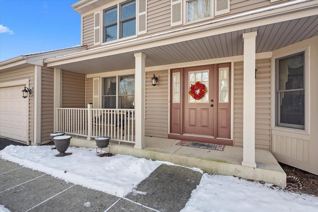 snow covered property entrance with covered porch