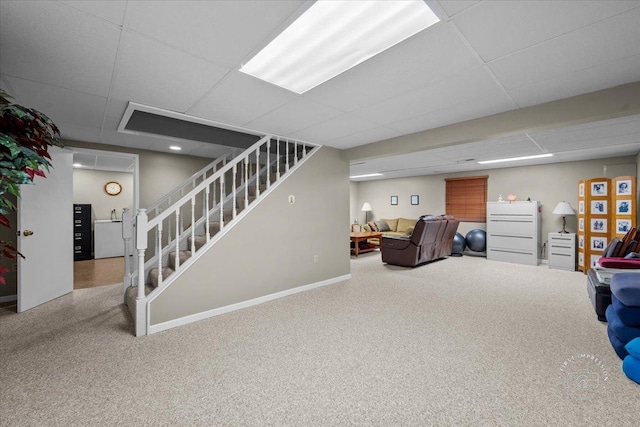 living room featuring carpet and a drop ceiling