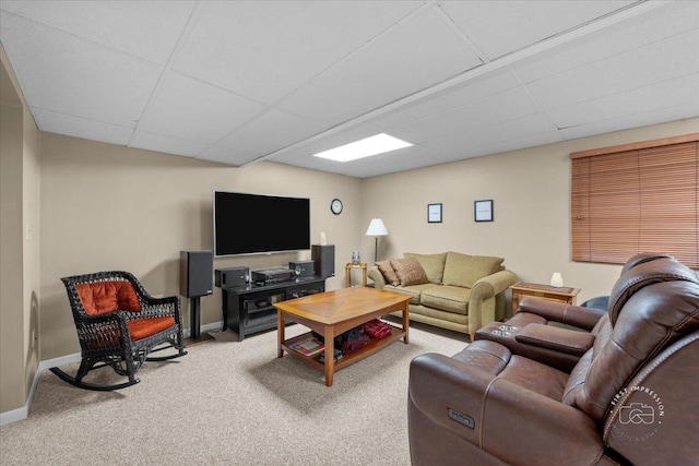 living room with a paneled ceiling and carpet flooring