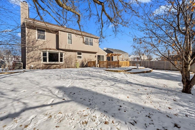 snow covered house featuring a deck