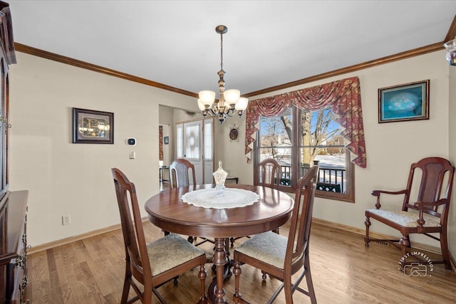 dining space featuring ornamental molding, light hardwood / wood-style flooring, and a chandelier