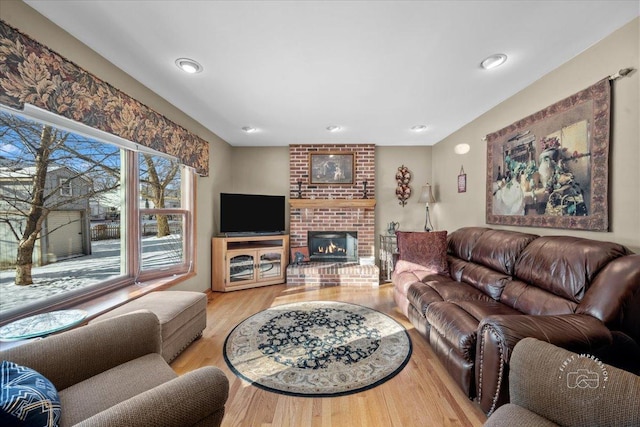 living room with a fireplace and light wood-type flooring