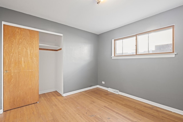 unfurnished bedroom featuring light hardwood / wood-style floors and a closet