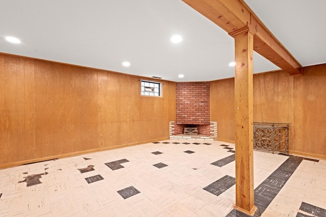 basement featuring wooden walls and a fireplace