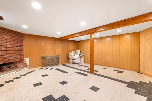 basement featuring a fireplace and wood walls