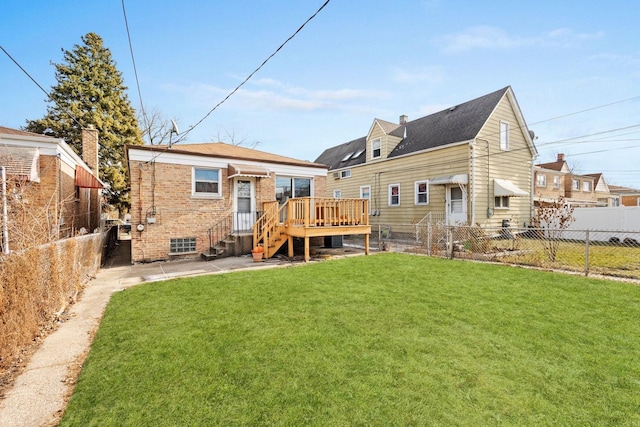 rear view of house featuring a lawn and a deck