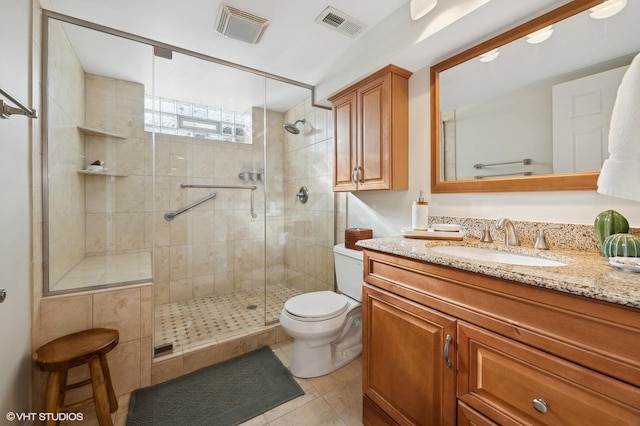 bathroom with toilet, vanity, tile patterned floors, and a shower with shower door