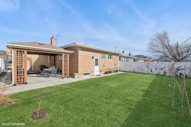 back of house featuring a patio area and a lawn