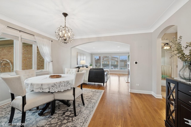 dining room featuring crown molding, an inviting chandelier, and light hardwood / wood-style flooring