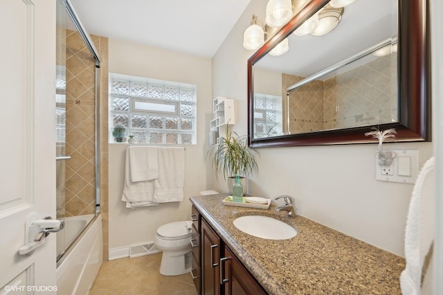 full bathroom featuring tile patterned flooring, vanity, bath / shower combo with glass door, and toilet