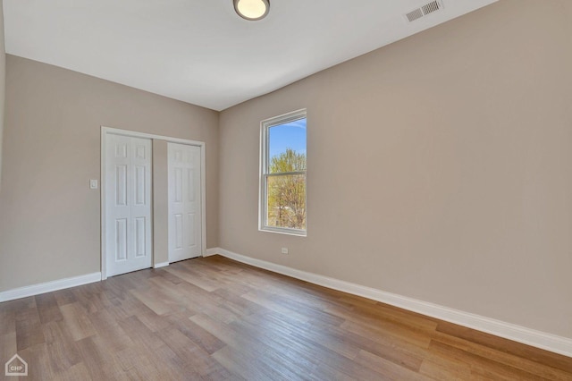 unfurnished bedroom with a closet and light wood-type flooring