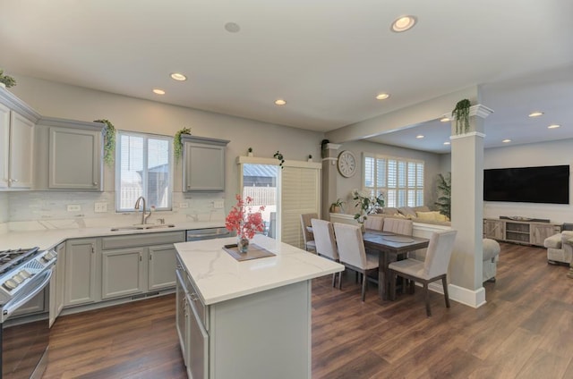 kitchen featuring a kitchen island, stainless steel appliances, decorative backsplash, sink, and gray cabinets