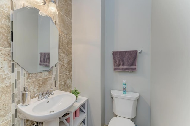 bathroom with tasteful backsplash, sink, and toilet