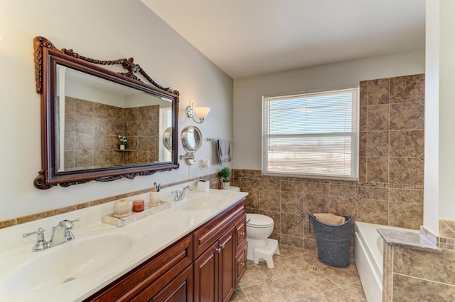 bathroom with toilet, vanity, tile patterned flooring, tile walls, and a tub