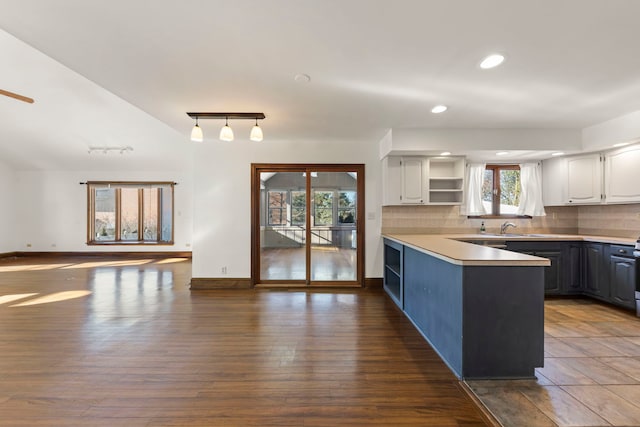 kitchen with sink, white cabinets, backsplash, dark hardwood / wood-style floors, and pendant lighting