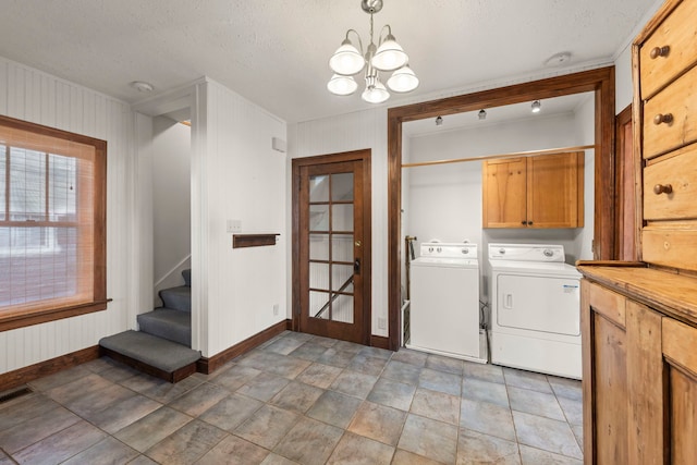 laundry area featuring a textured ceiling, a notable chandelier, french doors, cabinets, and washing machine and clothes dryer