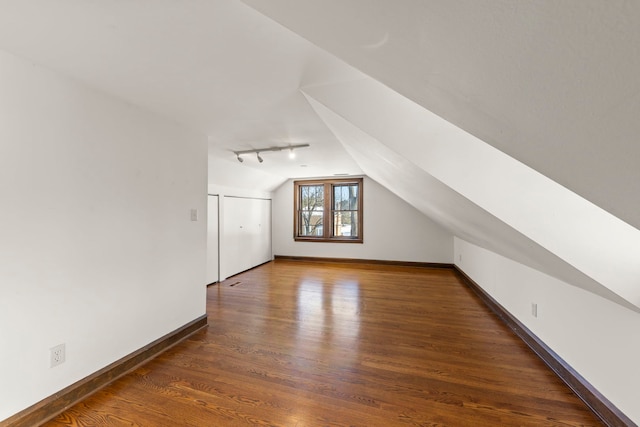 additional living space with vaulted ceiling and dark hardwood / wood-style floors