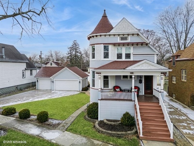 victorian house with an outbuilding, a garage, covered porch, and a front yard