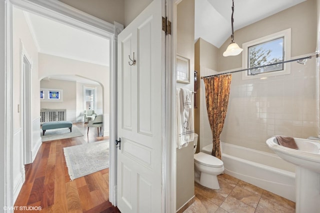 bathroom featuring shower / bathtub combination with curtain, tile patterned floors, and toilet