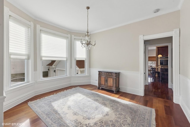 dining room with an inviting chandelier, ornamental molding, and dark hardwood / wood-style floors