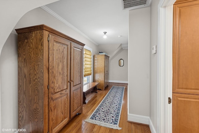 corridor with crown molding and light wood-type flooring