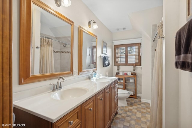 bathroom featuring vanity, walk in shower, and toilet