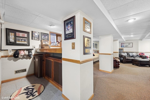 bar featuring light carpet and a paneled ceiling