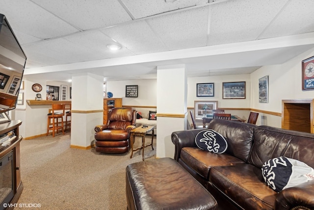 living room featuring a drop ceiling and carpet floors