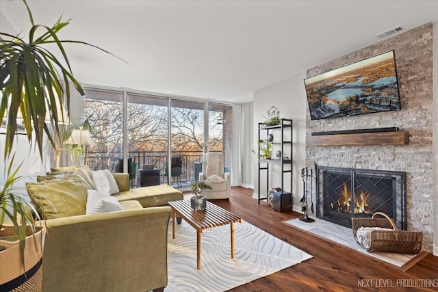 living room with hardwood / wood-style floors, expansive windows, and a fireplace